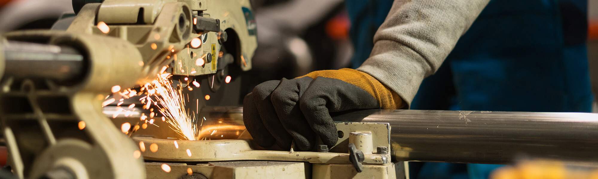 Worker working with a circular grinder on a metal with sparks